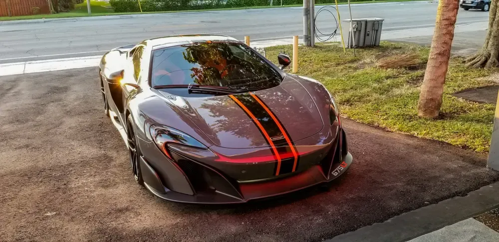 Dark McLaren with orange racing stripes